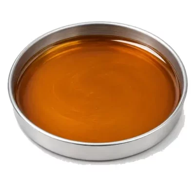 Representative amber structural adhesive resin in a shallow stainless steel sample dish