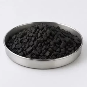 Irregular black elastomer crumbs in a stainless steel sample dish
