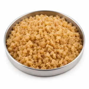Natural rubber granules and pellets in a shallow stainless steel dish
